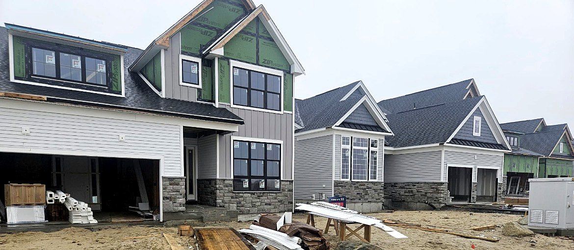 Several new homes being sided at once on a new development street