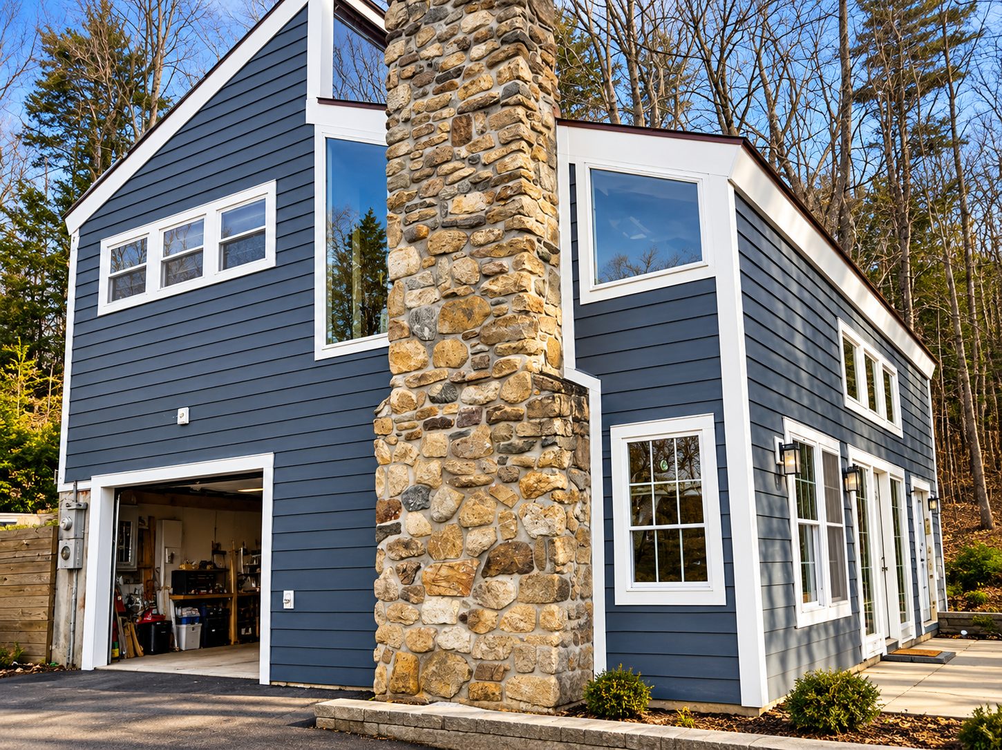 Finished home with navy lap siding, white trim and stone chimney
